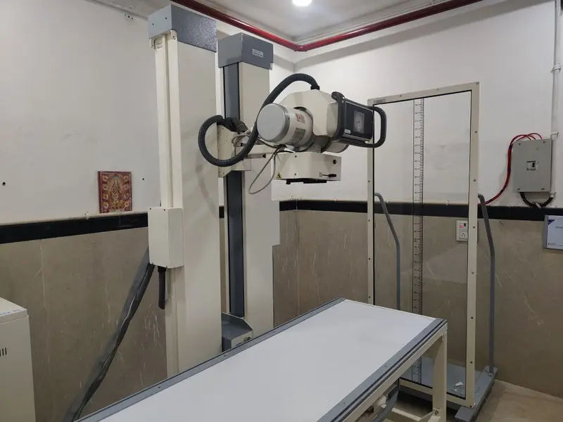 X-ray room at Om Imaging Centre with a wall-mounted X-ray tube and examination table